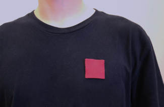 Individu portant le symbole des grévistes, le carré rouge.
